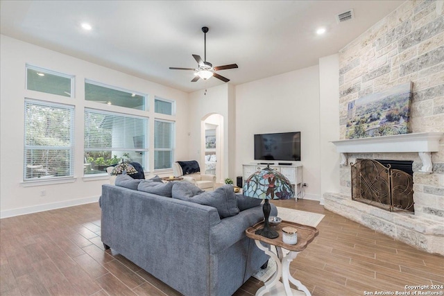 living room featuring a fireplace, hardwood / wood-style floors, and ceiling fan