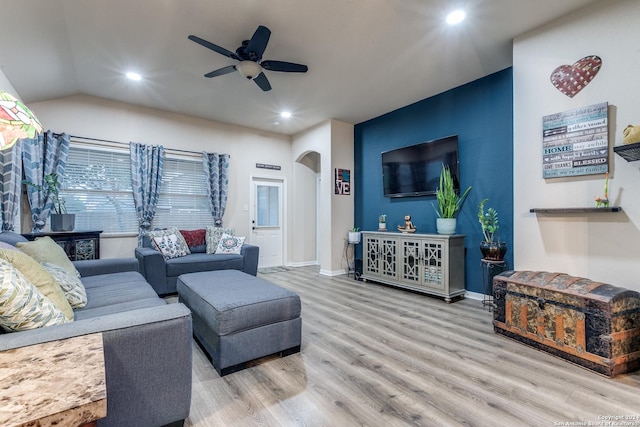 living room with ceiling fan, lofted ceiling, and light hardwood / wood-style flooring