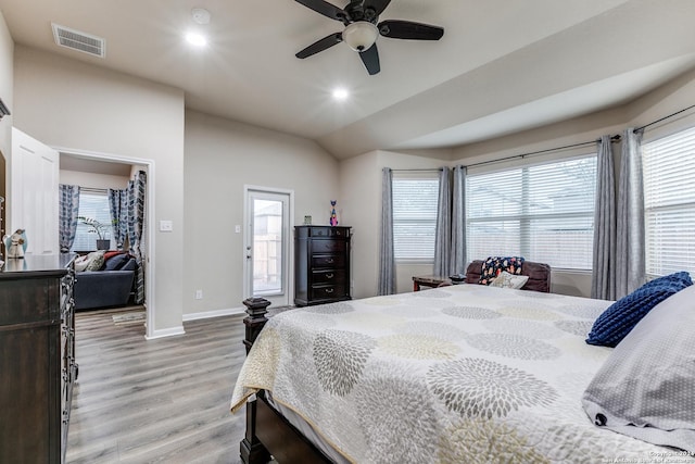 bedroom with multiple windows, ceiling fan, vaulted ceiling, and light wood-type flooring