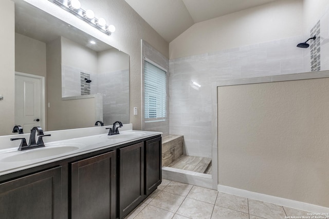 bathroom with tile patterned flooring, vaulted ceiling, and tiled shower