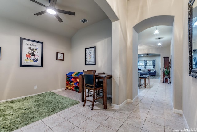 interior space featuring ceiling fan, light tile patterned flooring, and lofted ceiling