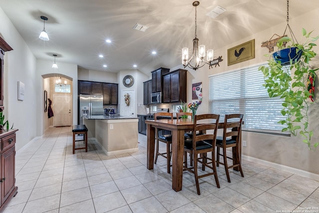 tiled dining room featuring a chandelier