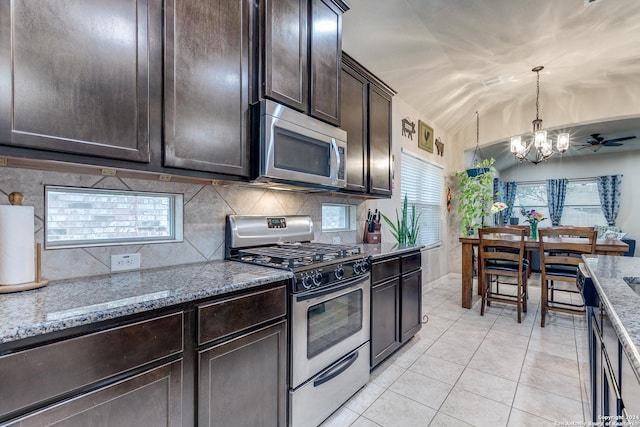 kitchen with light stone countertops, appliances with stainless steel finishes, tasteful backsplash, and lofted ceiling