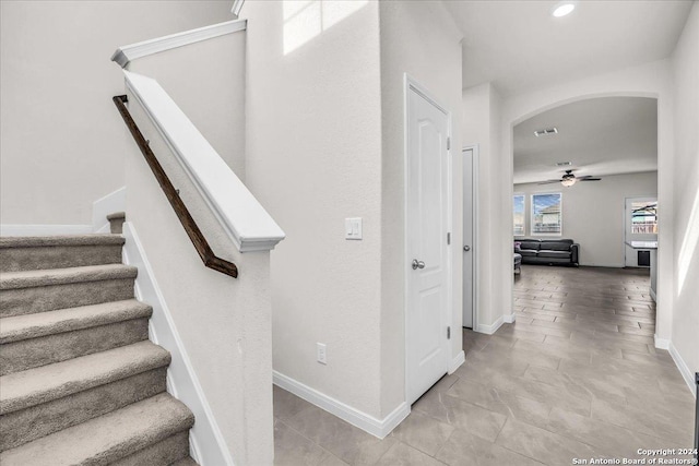 staircase with tile patterned floors and ceiling fan