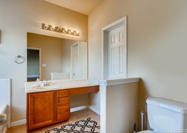 bathroom featuring vanity, a bath, and toilet