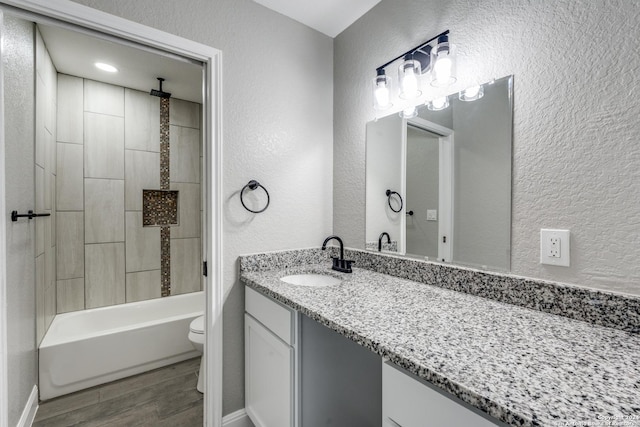 full bathroom with bathing tub / shower combination, toilet, vanity, and hardwood / wood-style flooring