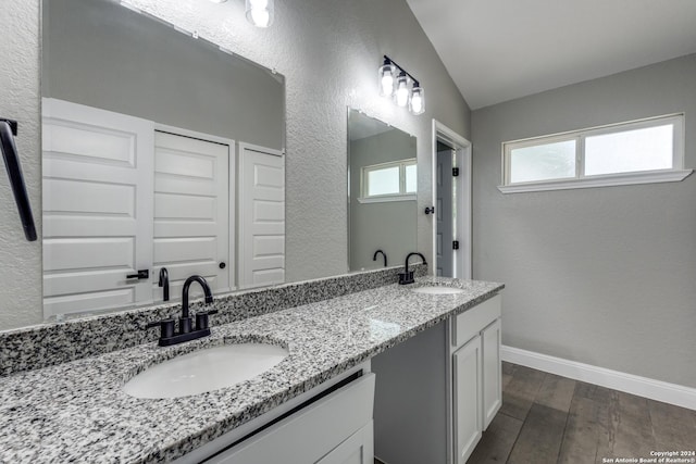 bathroom with vanity, lofted ceiling, and hardwood / wood-style flooring