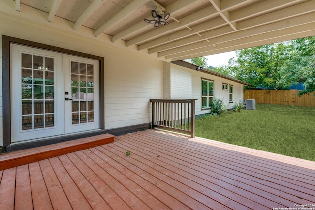 wooden terrace featuring french doors, central air condition unit, and a lawn