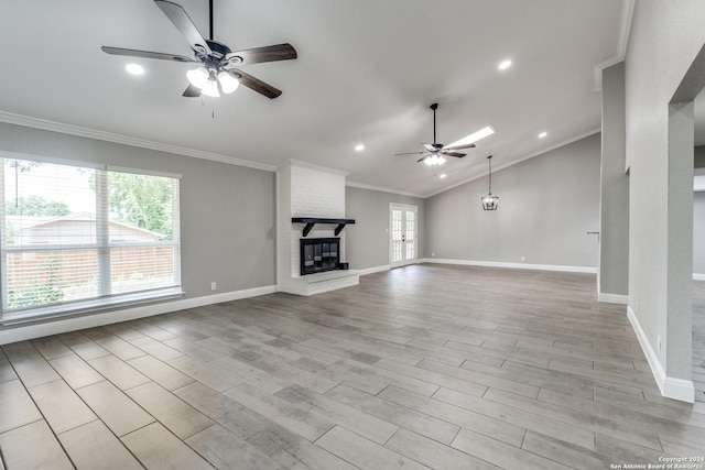 unfurnished living room featuring lofted ceiling, a brick fireplace, ceiling fan, light wood-type flooring, and ornamental molding