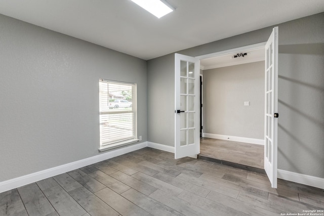 unfurnished bedroom featuring french doors and light wood-type flooring