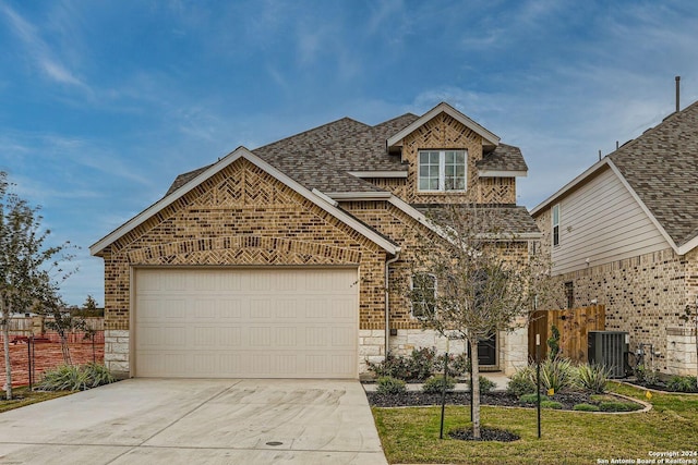 front facade featuring a garage, a front yard, and central AC