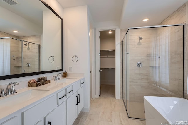 bathroom with vanity and shower with separate bathtub