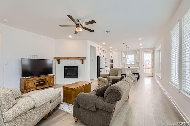 living room featuring light hardwood / wood-style floors, ceiling fan, and sink