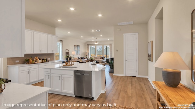 kitchen featuring light wood-type flooring, a kitchen island with sink, ceiling fan, dishwasher, and white cabinetry