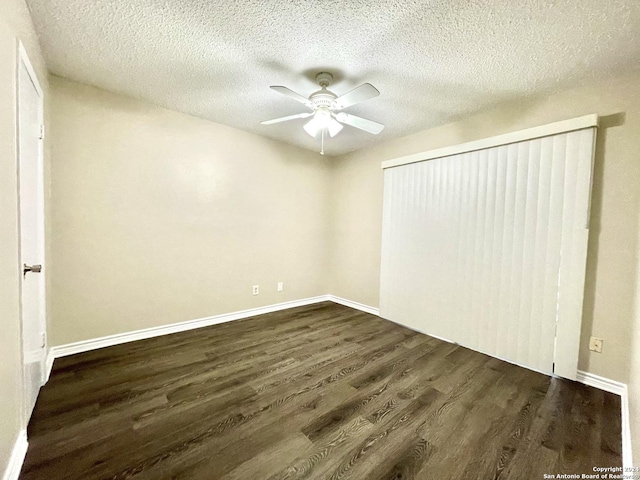 unfurnished bedroom featuring ceiling fan, dark wood-type flooring, and a textured ceiling