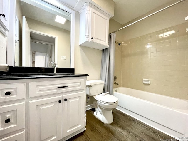 full bathroom with hardwood / wood-style floors, vanity, shower / tub combo, and toilet