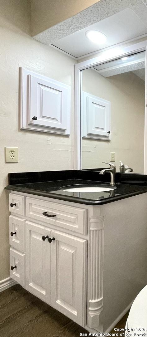 bathroom featuring hardwood / wood-style floors, vanity, and toilet