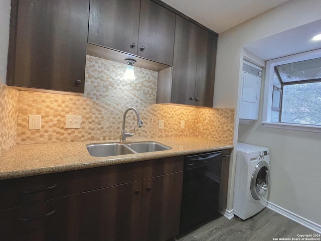 kitchen with tasteful backsplash, sink, stacked washer / drying machine, and black dishwasher