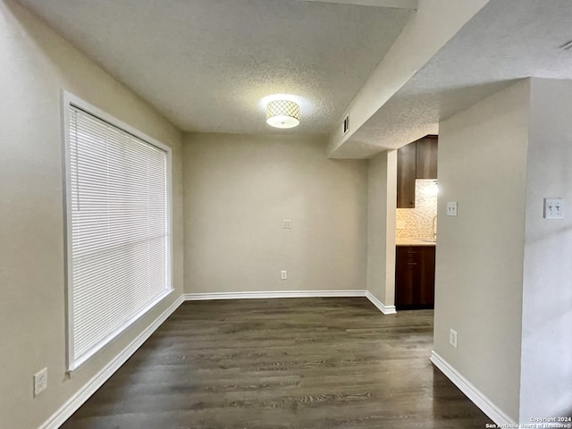 unfurnished dining area with dark hardwood / wood-style floors and a textured ceiling