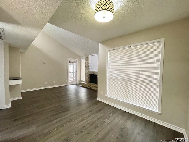 unfurnished living room featuring a fireplace, dark hardwood / wood-style flooring, a textured ceiling, and vaulted ceiling