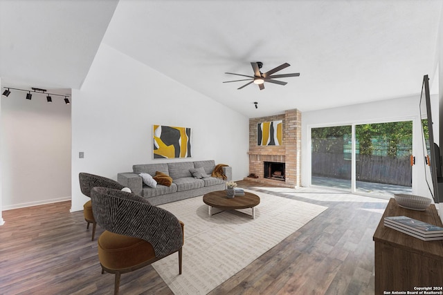 living room featuring ceiling fan, wood-type flooring, a fireplace, and vaulted ceiling