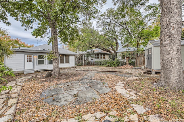 rear view of property featuring a patio and a shed