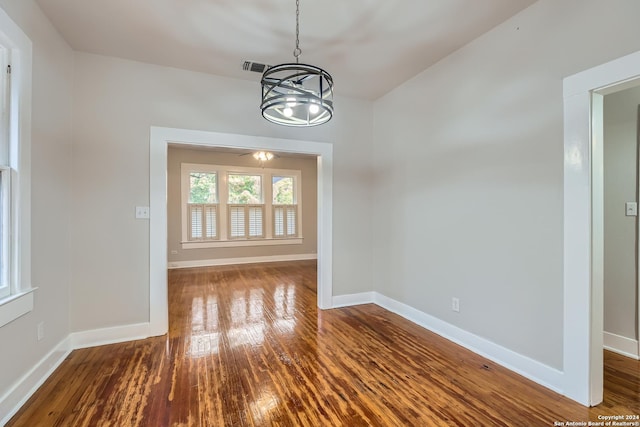 unfurnished dining area featuring a notable chandelier and wood-type flooring