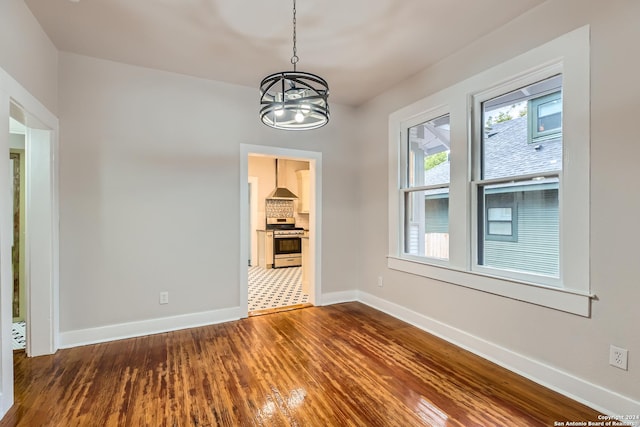 spare room with wood-type flooring and a notable chandelier