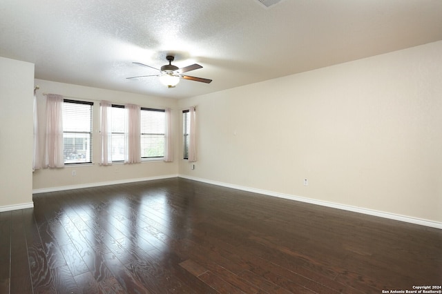 spare room with dark hardwood / wood-style floors, ceiling fan, and a textured ceiling