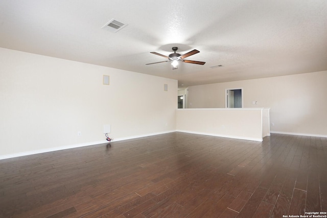 spare room featuring a textured ceiling, ceiling fan, and dark wood-type flooring