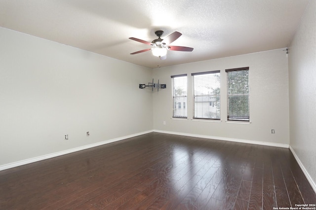 unfurnished room with a textured ceiling, ceiling fan, and dark wood-type flooring