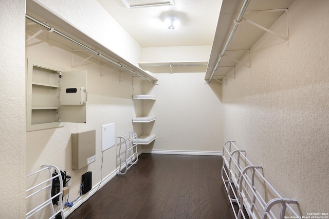 walk in closet with dark wood-type flooring