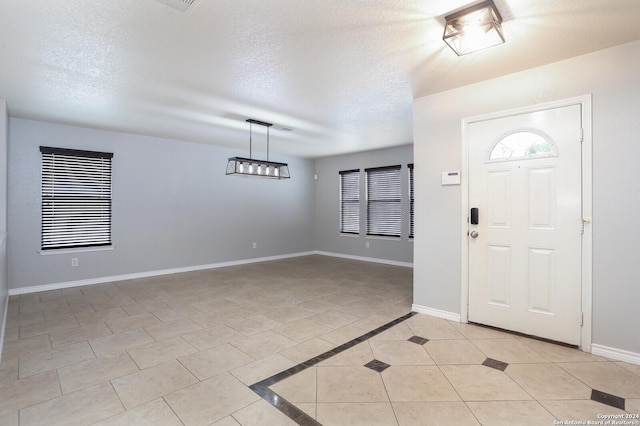 tiled entryway featuring a textured ceiling