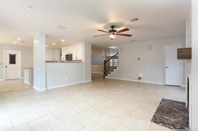 unfurnished living room with ceiling fan and light tile patterned floors