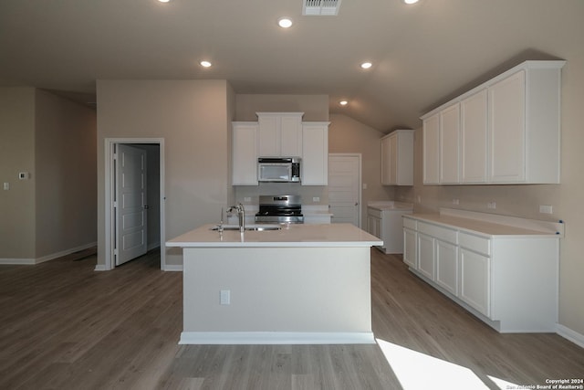 kitchen featuring sink, white cabinetry, stainless steel appliances, light hardwood / wood-style floors, and an island with sink