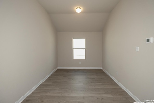 empty room with lofted ceiling and light hardwood / wood-style floors