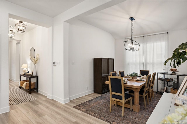 dining space with an inviting chandelier and light hardwood / wood-style flooring