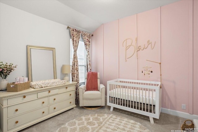 bedroom featuring light carpet, vaulted ceiling, and a nursery area