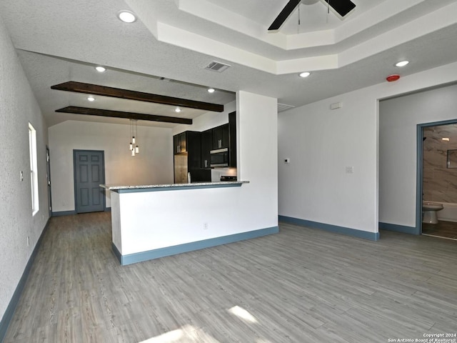 kitchen featuring pendant lighting, hardwood / wood-style flooring, ceiling fan, beamed ceiling, and kitchen peninsula