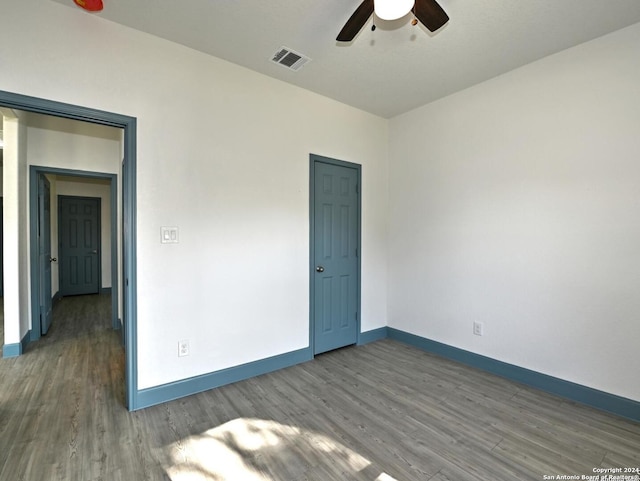 empty room featuring dark hardwood / wood-style flooring and ceiling fan