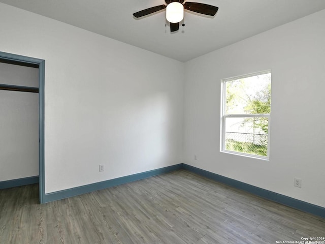 unfurnished bedroom with wood-type flooring, a closet, and ceiling fan