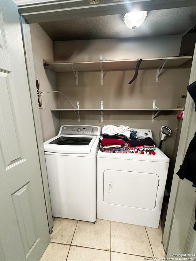 laundry room featuring separate washer and dryer and light tile patterned floors