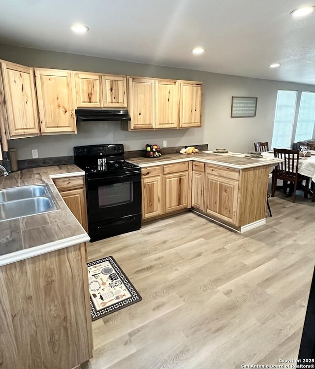 221 Chaparral St, Uvalde, TX 78801 - kitchen featuring black range, under cabinet range hood, light brown cabinetry, a peninsula, and recessed lighting