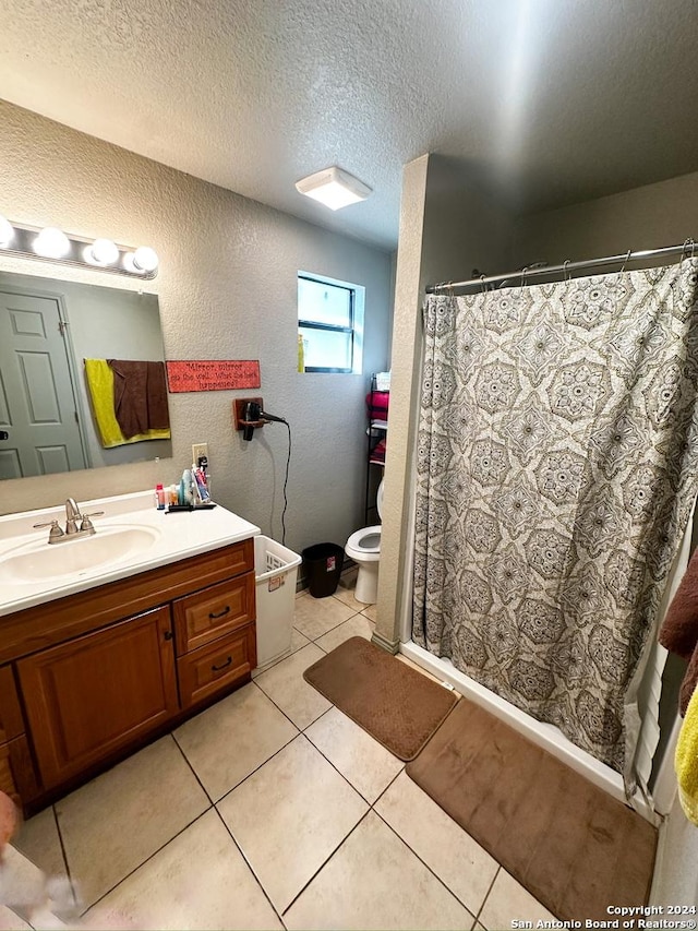 bathroom with tile patterned floors, vanity, toilet, and a textured ceiling