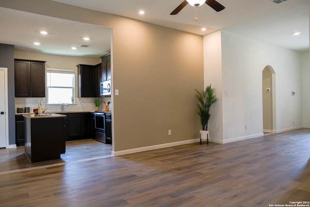 kitchen featuring decorative backsplash, appliances with stainless steel finishes, dark hardwood / wood-style flooring, and a kitchen island