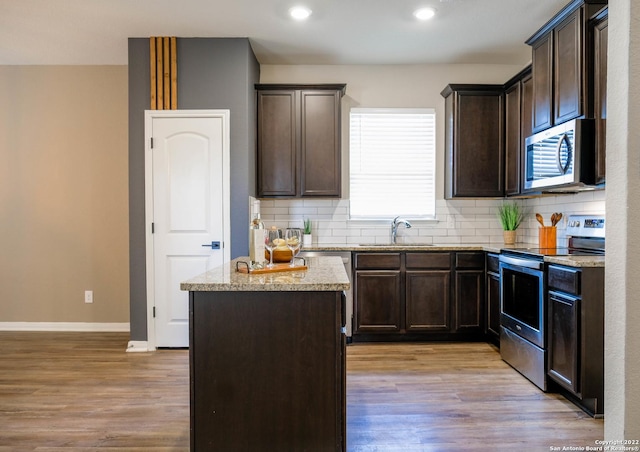 kitchen featuring stainless steel appliances, light hardwood / wood-style flooring, plenty of natural light, and sink