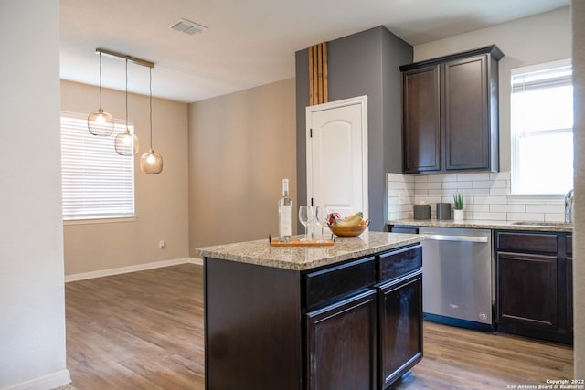 kitchen featuring light wood-type flooring, dark brown cabinetry, decorative light fixtures, dishwasher, and a kitchen island