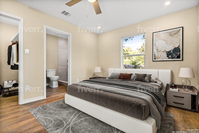 bedroom featuring dark hardwood / wood-style floors, ceiling fan, and connected bathroom