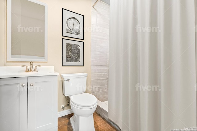 bathroom featuring curtained shower, hardwood / wood-style floors, vanity, and toilet