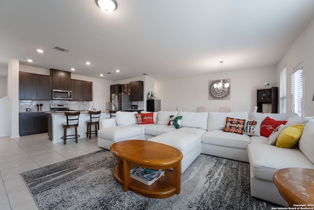 living room featuring light tile patterned floors and an inviting chandelier